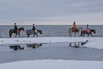 Horseback riding by the sea.